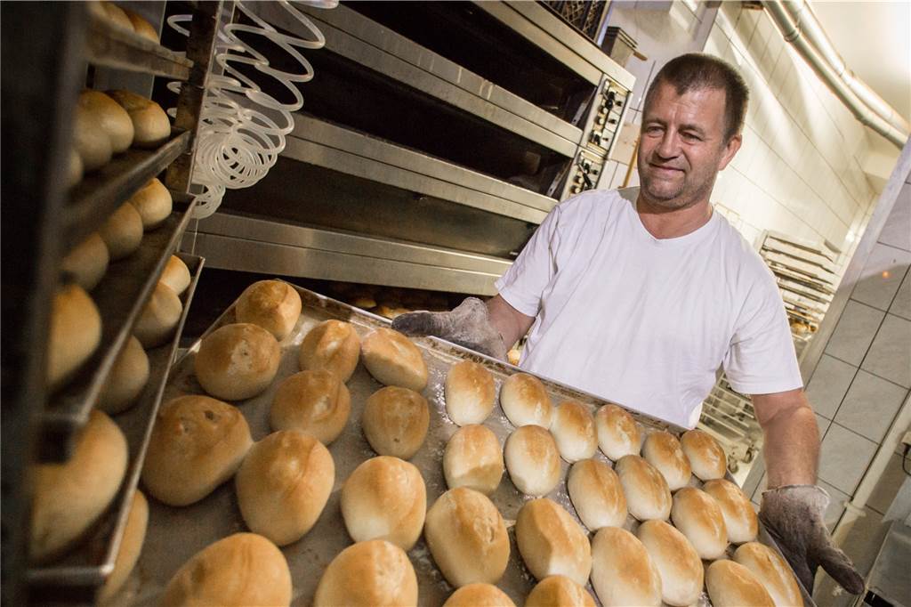 Allerheiligen: Diese Bäckereien und Hofläden haben geöffnet Ein Bäcker holt ein Blech mit Brötchen aus dem Ofen.