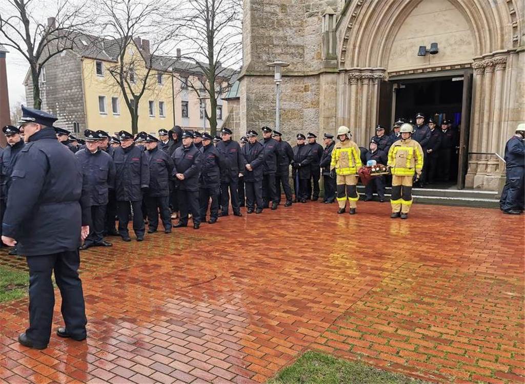 Feuerwehrmann Josef Pieper gestorben – Ein Leben für den Trupp Viele Feuerwehrleute kamen zur Beerdigung ihres Kameraden Josef Pieper in Castrop-Rauxel. Sie stehen vor der St. Lambertus Kirche in Henrichenburg. Zwei Feuerwehrleute tragen die Urne aus der Kirche.