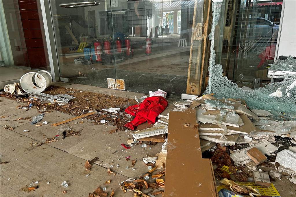 Vandalismus in der Innenstadt: Fenster bei leer stehendem Geschäft eingeschlagen Viele Glasscherben und Müll liegen vor dem zum Verkauft stehenden Geschäft.