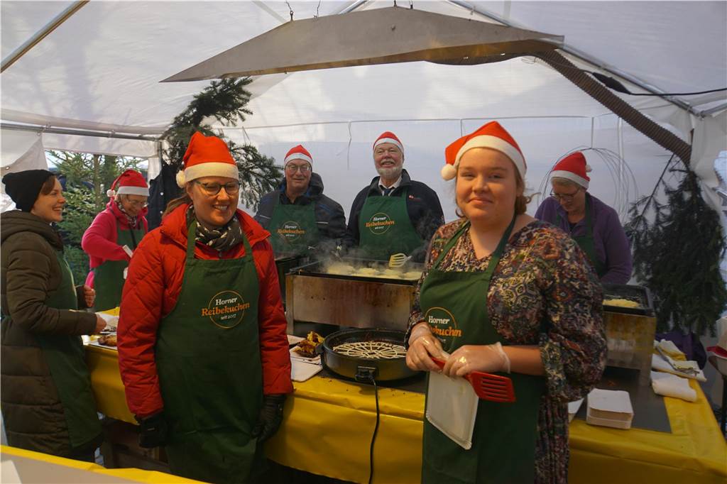Weihnachtsmarkt lockt hunderte Menschen an: Geschenkideen und ein Abschied Menschen mit Nikolaus-Mützen