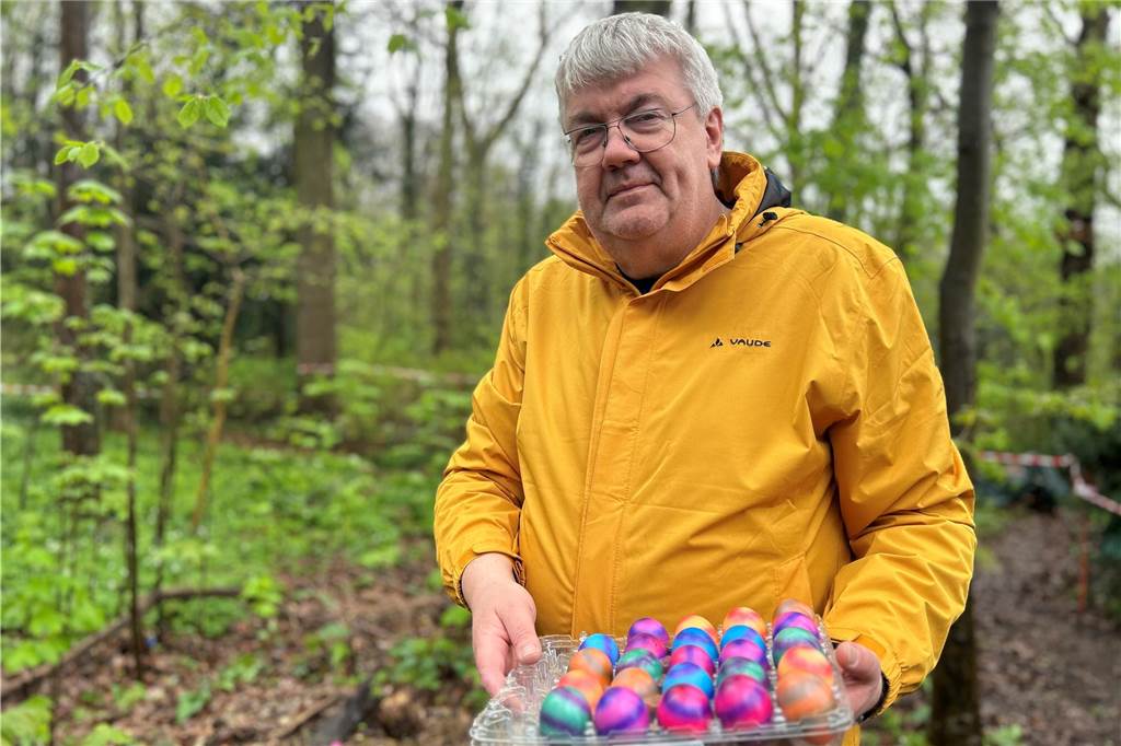 Ein Mann, der eine Palette bunte Eier hält.