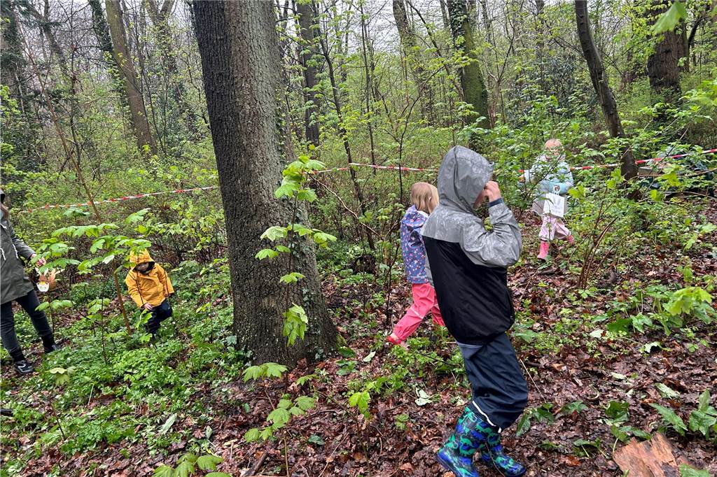 Kinder, die nach Ostereiern im Wald suchen.