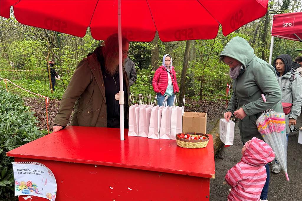 Menschen, die an einem roten Stand stehen.