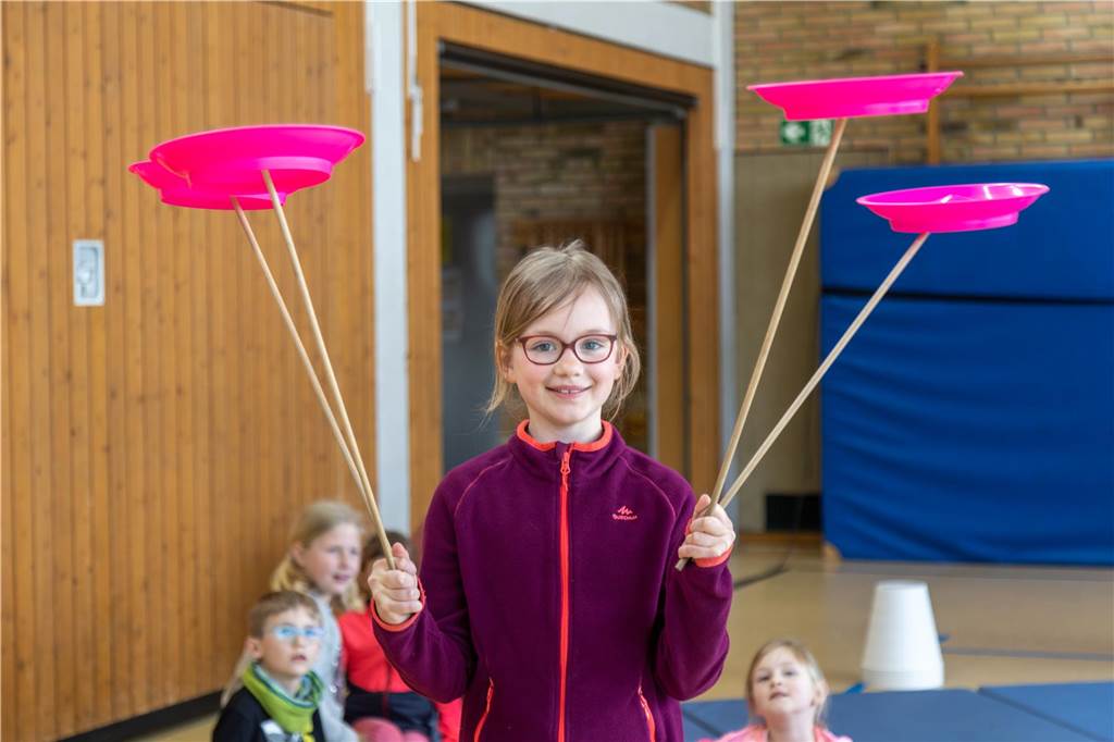 Mädchen balanciert vier Teller in Heek