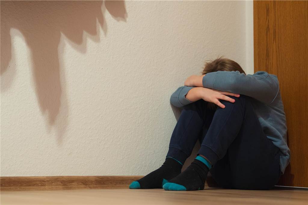 Ute Lorenz ist die erste Kinderschutzbeauftragte der Stadt Dorstens Ein Junge kauert in einer Zimmerecke