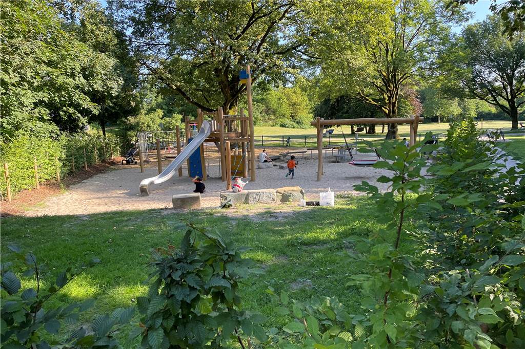 Vier Kinder spielten am Freitagabend auf dem neuen Spielplatz im Schatten der alten Bäume. Am Wochenende könnte es hier noch voller werden. Der Mülleimer lief aber schon am Freitag über. 