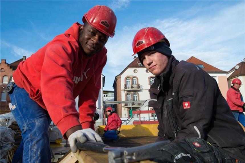 Vincent Ahondoh (l) und Sven Hofmann, zwei Auszubildende in der Bauwirtschaft, auf einer Baustelle in Esslingen. Foto: Sina Schuldt