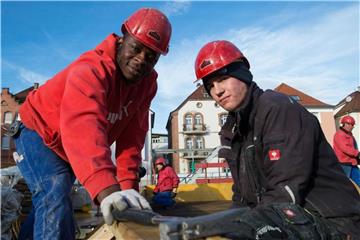 Vincent Ahondoh (l) und Sven Hofmann, zwei Auszubildende in der Bauwirtschaft, auf einer Baustelle in Esslingen. Foto: Sina Schuldt