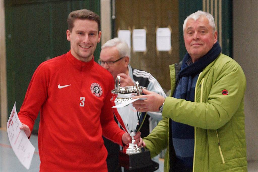 Fusionen von Mannschaften? Neuer Chef des Stadtsportverbands will den Unnaer Fußball umkrempeln Volker König überreichte 2018 als Sportausschuss-Vorsitzender den Siegerpokal bei den Unnaer Hallenfußball-Stadtmeisterschaften an Mühlhausens Stephen Hutmacher. Dahinter applaudiert Königs Vorgänger im Stadtsportverband Unna, Bodo Micheel.