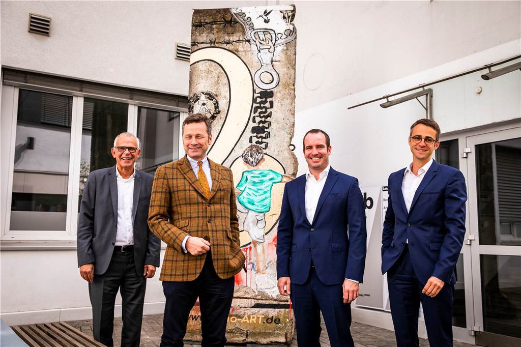 Stücke der Berliner Mauer stehen bei Lensing Media Volker Stennei, Lambert Lensing-Wolff, Hans-Christian Haarmann und Dr. Daniel Süper (v.l.) haben die beiden Mauerstücke zum 150-jährigen Jubiläum des Verlages im Empfang genommen.