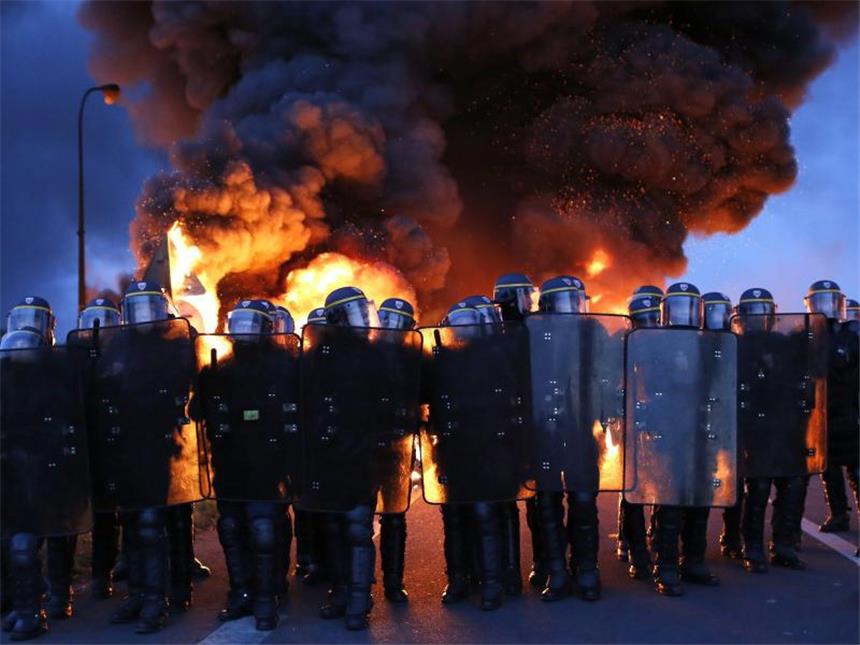 Sprit-Blockaden treffen jede dritte Tankstelle in Frankreich Volkszorn: Französische Polizisten an einer Blockade aus brennenden Autoreifen. Seit Wochen protestieren die Franzosen gegen eine Arbeitsmarktreform. Foto: Thibault Vandermersch