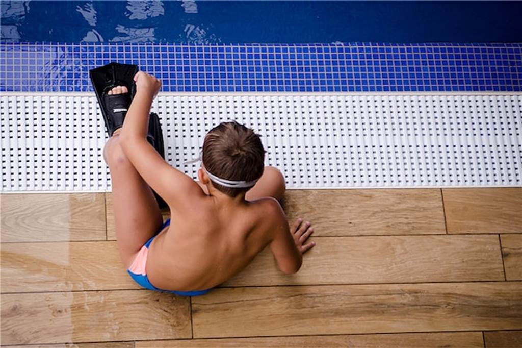 Hier kommen Sie zum Zug: 9 beliebte Sportbäder in NRW junge sitzt mit schwimmflossen am beckenrand