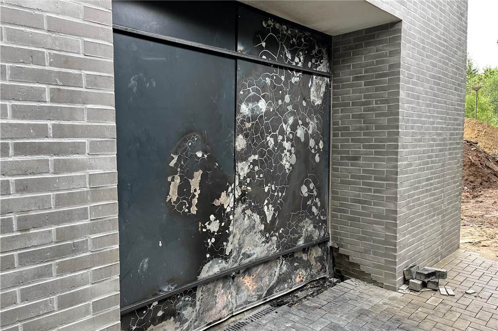 Feuer in Turnhalle: Spürhund der Polizei findet Brandbeschleuniger Von außen deutet am Montagmorgen (24.7.) an dem neuen Turnhallen-Neubau nicht viel auf den Brand im Innern von Sonntag hin. Doch hier an der Außentür sind die Spuren auch von draußen deutlich zu sehen