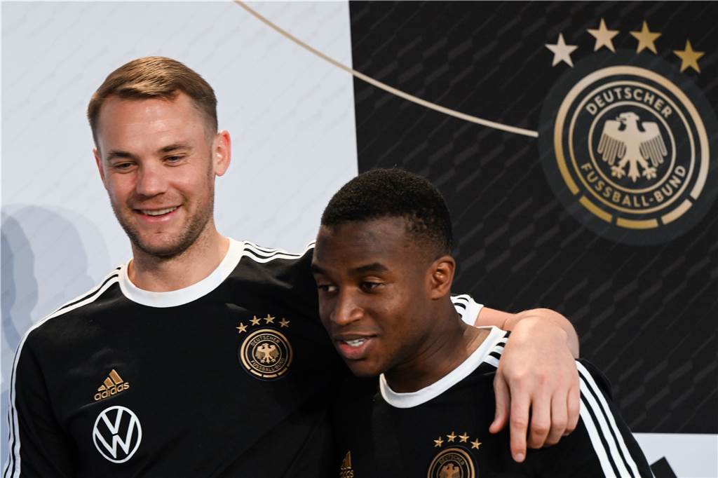 BVB-Juwel Moukoko über seine Zukunft: „Ich würde wirklich gerne in Dortmund bleiben“ Manuel Neuer legt einen Arm um Youssoufa Moukoko.