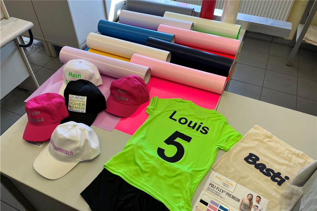 Familie Schmalöer bedruckt individuelle T-Shirts und Hoodies Kleidung liegt auf einem Tisch.