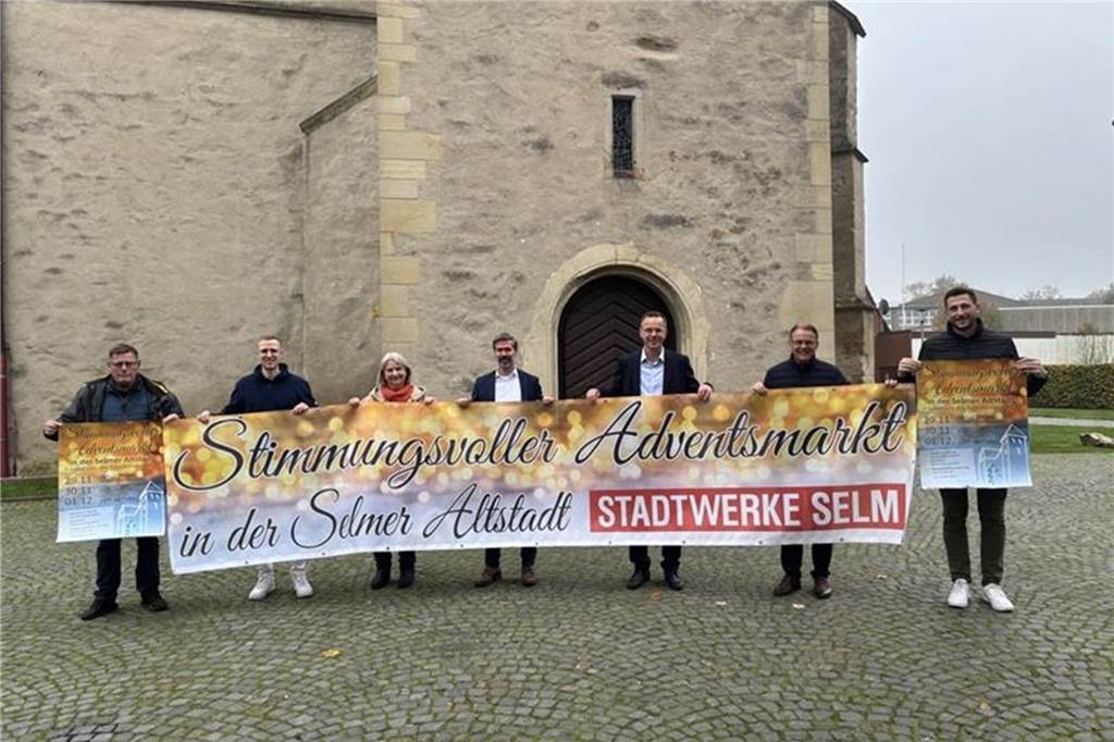 Adventsmarkt: Neben Traditionen gibt es auch zwei neue Programmpunkte Sieben Menschen halten Plakate und einen Banner fest.