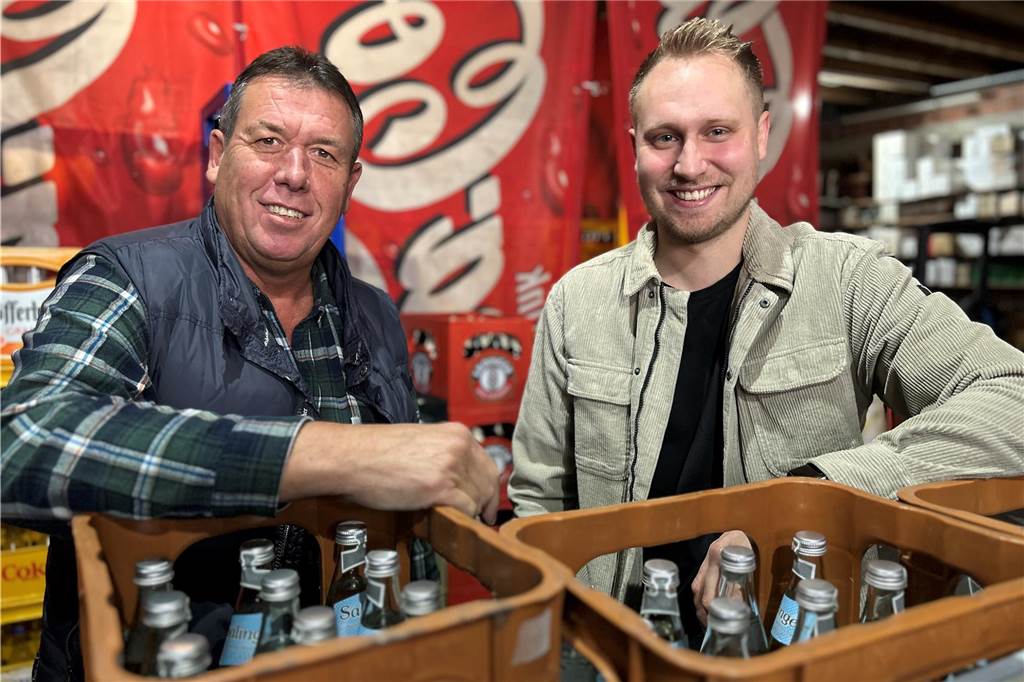 Peter Abel und Simon Lemberg stehen hinter Mineralwasserkisten.