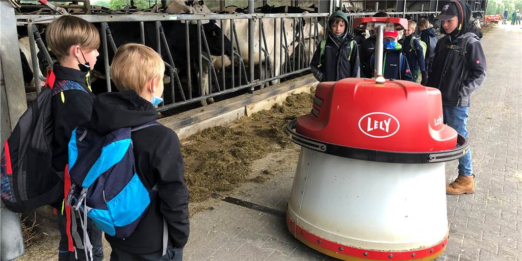 Schüler erleben Landwirtschaft mit Kühen und Roboter (mit Video) Schüler und der Futteranschiebe-Roboter auf dem Hof Fengels