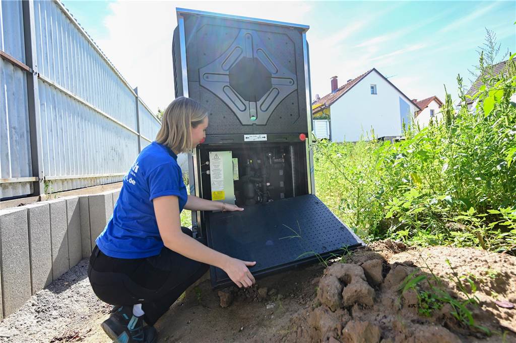Heizen in Lünen, Selm und Werne: Hoffnung auf neuen Wärmepumpen-Hype Eine Frau sitzt neben einer Wärmepumpe im Garten.