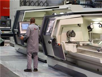 Vor Beginn der Weltleitmesse der Werkzeugmaschinenindustrie (EMO) steht ein Mitarbeiter an einer Drehmaschine auf dem Messegelände in Hannover. Foto: Sebastian Kahnert