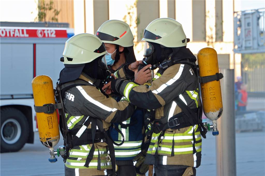 Mit Video: Menschen in Gefahr – Feuerwehrleute in verrauchter Halle aktiv Vor dem Innenangriff kontrollieren die Einsatzkräfte ihre Ausrüstung gegenseitig.