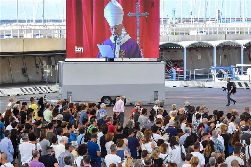 „Die Welt umarmt Genua“ Vor dem Messegelände Fiera di Genua verfolgt eine Menschenmenge die auf einer Leinwand übertragene Trauerfeier. Foto: Simone Arveda/AP