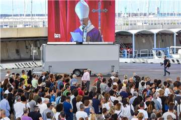 Vor dem Messegelände Fiera di Genua verfolgt eine Menschenmenge die auf einer Leinwand übertragene Trauerfeier. Foto: Simone Arveda/AP