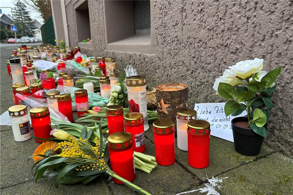 Vor dem Wohnhaus der getöteten Rita (71) in Hillen in Recklinghausen haben Menschen Grabkerzen, Blumen und Bonbons niedergelegt.