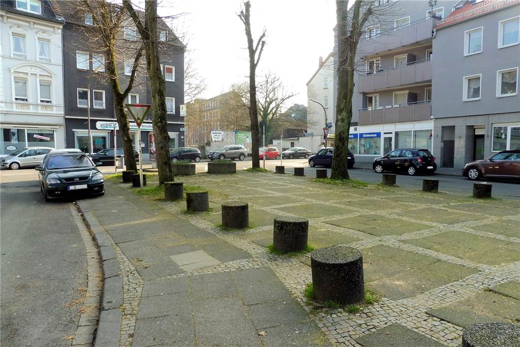 Sanierung: Ortskern lädt zum Flanieren ein – es bleiben Herausforderungen Vor der Sanierung: die Fläche zwischen Jonathan- (l.) und Adalmundstraße (r.) am Ehrenmal vor der Regenbogen-Grundschule.