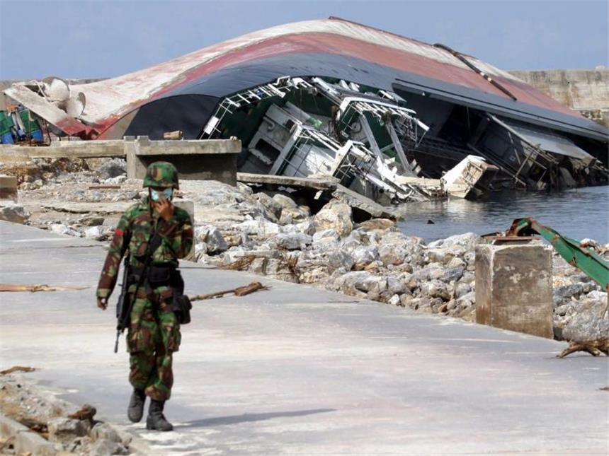 Plan-Chefin: «Wiederaufbau nach Tsunami hat gut funktioniert» Vor einem zerstörten Schiff läuft ein Soldat am 3. Januar 2005 über eine Straße in der Region Aceh. Foto: Ardiles Rante/Archiv