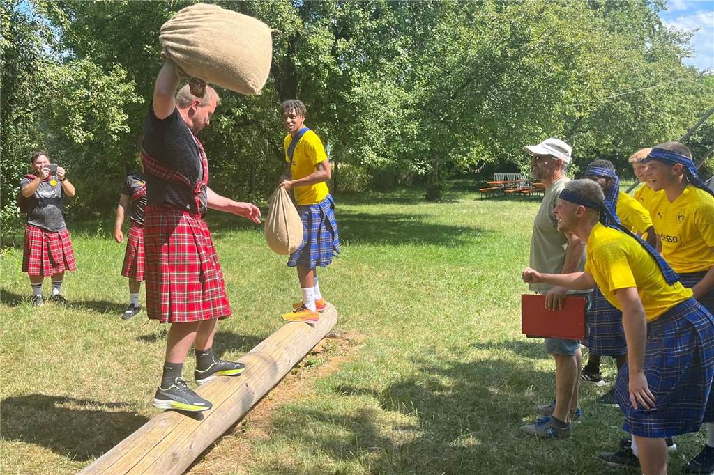 BVB-U19 mit Teambuildingmaßnahme im Schottenrock: Ungewöhnlicher Wettstreit bei Highland Games Martin Kempa und Filippo Mane balancieren über einen Baumstamm.