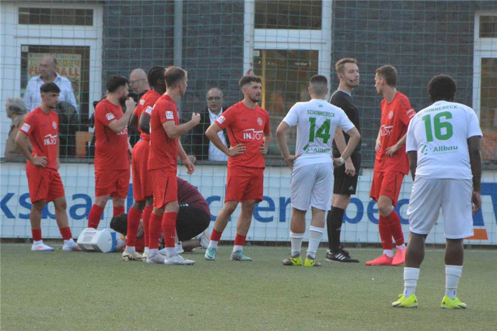 Spieler des SV Schermbeck stehen neben dem verletzten Mustafa Gürpinar