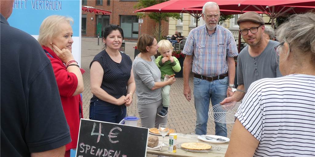 Mit selbst gebautem Waffelofen auf dem Markt in Olfen: Aktion für guten Zweck Während Tobias Mehring (r.) die Waffeln backt, sorgen Mitglieder des Arbeitskreises Asyl für den Verkauf: (v.l.) Rita Watermann, Fatbardha Rade, Kundin Birgit Reck mit Enkel Emil und Heiner Dieckmann.