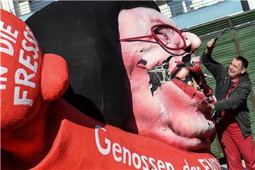 Wagenbauer Jacques Tilly zerstört einen Mottowagen vom Karneval. Foto: Federico Gambarini