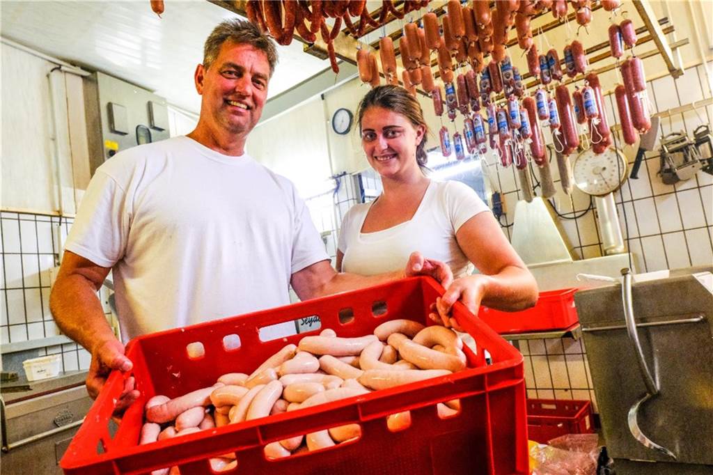 Walter Kranefoer hält Kennzeichnungspflicht für Augenwischerei Walter Kranefoer und Tochter Annabelle halten in ihrer Metzgerei in Waltrop eine rote Plastikwanne mit rohen Würsten in den Händen. (Archivbild)