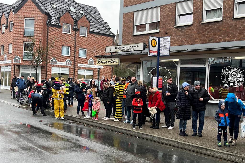Zuschauer des Umzugs feiern ausgelassen - Regen und Wind zum Trotz Am Straßenrand wartende Zuschauer.