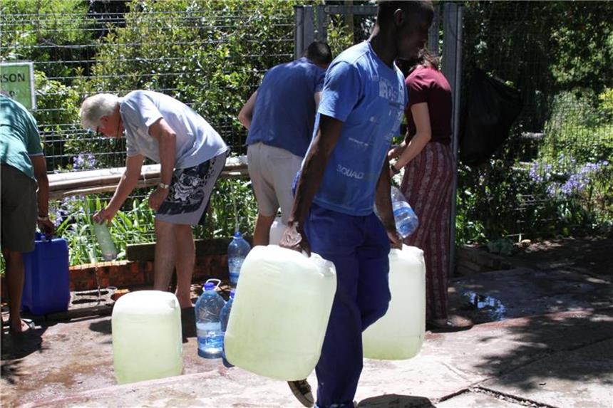 Drastische Verknappung: Kapstadt hat zu wenig Trinkwasser Wasser schleppen: Bewohner von Kapstadt füllen Wasserkanister an einer natürlichen Quelle in auf. Foto: Kristin Palitza