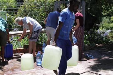 Wasser schleppen: Bewohner von Kapstadt füllen Wasserkanister an einer natürlichen Quelle in auf. Foto: Kristin Palitza