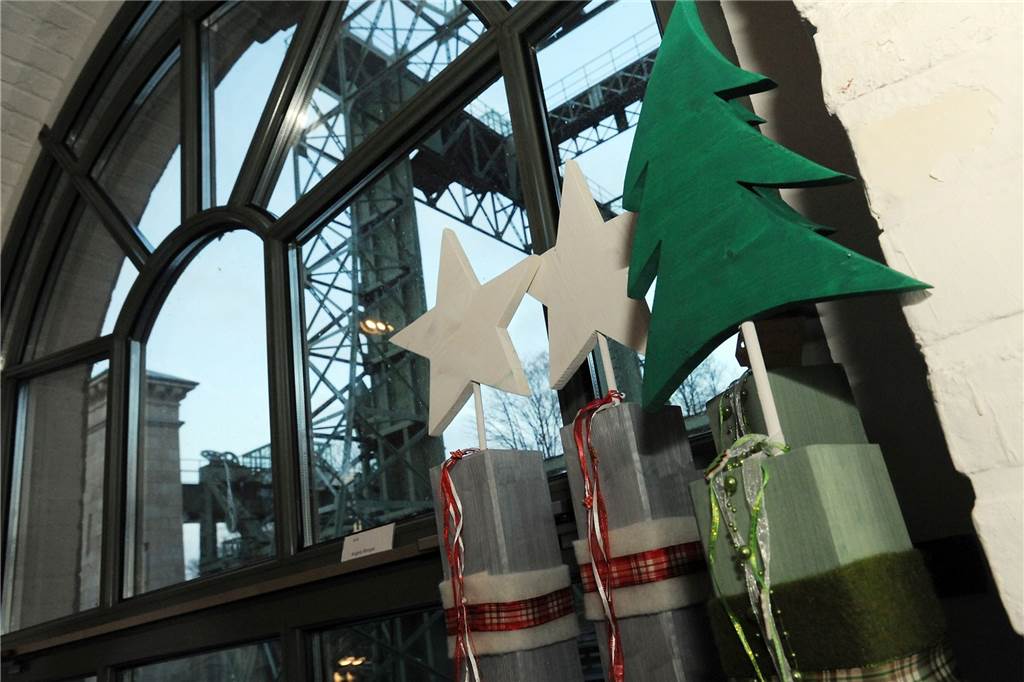 Ein Deko-Tannenbaum und zwei Deko-Sterne stehen vor einem Gebäude auf dem Gelände des Schiffshebewerks-Museums Henrichenburg in Waltrop. 