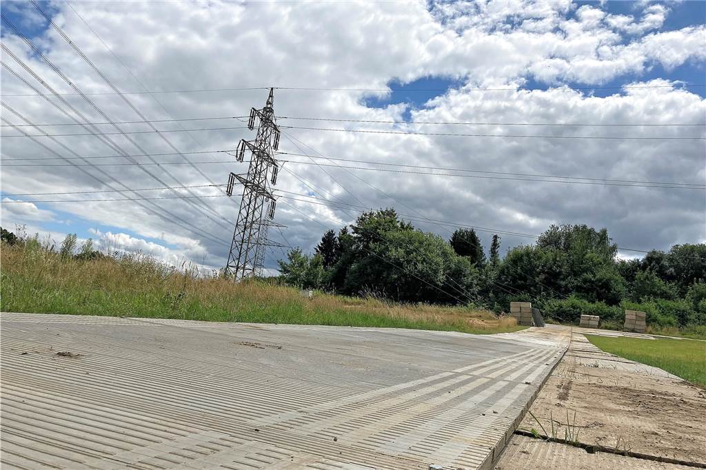 Abbau geht weiter: Strommasten verlieren nach und nach die Strippen Weit ins Feld hinein ist der Boden mit Stahlplatten ausgelegt, damit schweres Gerät hier fahren kann.