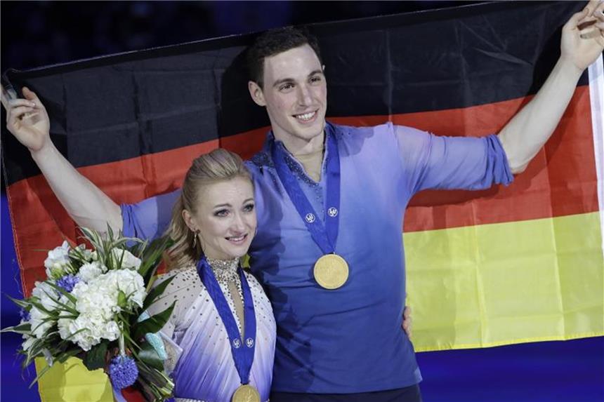 Savchenko/Massot veredeln Olympiasieg mit WM-Titel Weltmeister mit Bestnote: Aljona Savchenko und Bruno Massot mit Medaillen und Fahne. Foto: Luca Bruno