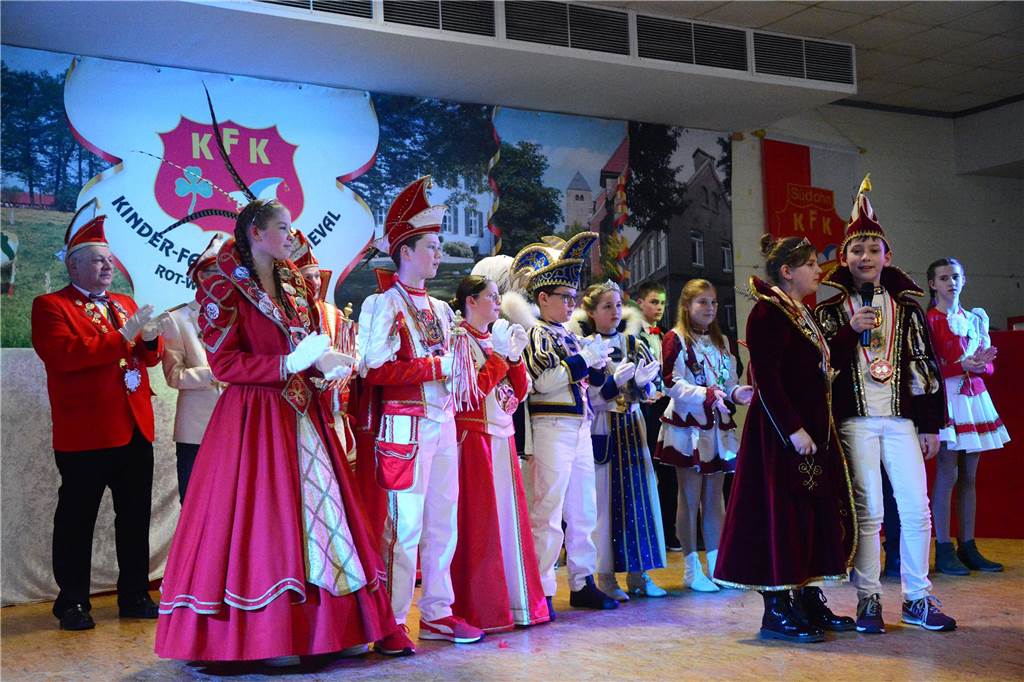 Auf der Bühne stehen mehrere Prinzenpaare nebeneinander und klatschen.