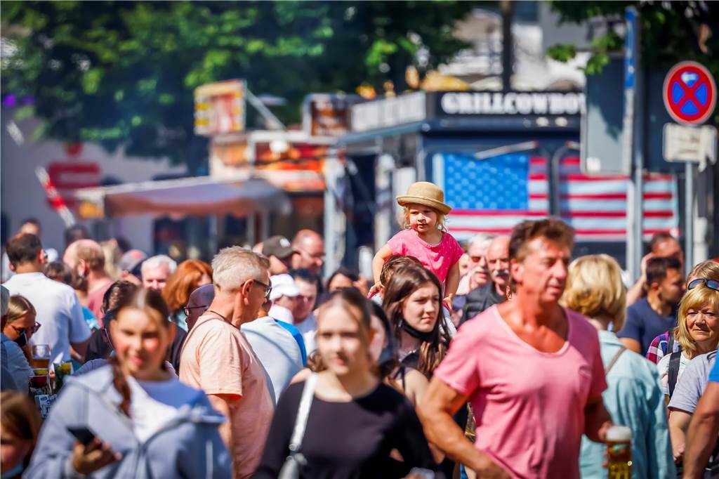 „Pingsthuekke“: Stadt sperrt Straßen und verlegt den Wochenmarkt Bummelnde Kirmesbesucher in Huckarde an Pfingsten 2022. Im Hintergrund: Kirmesbuden.