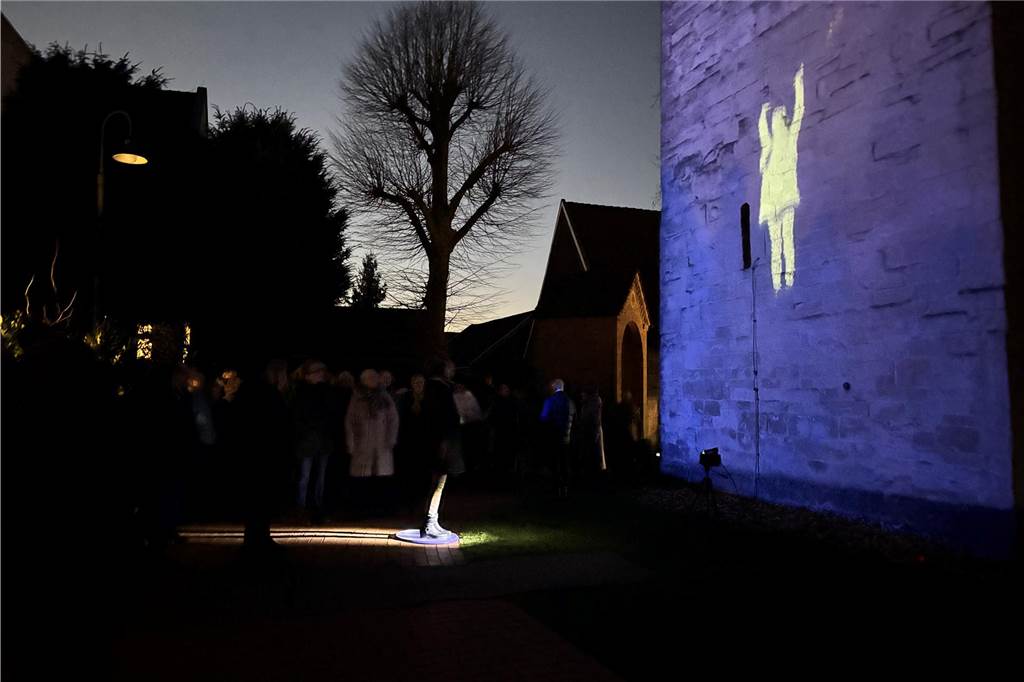 Kunstinstallation begeistert beim Asbecker Lichterglanz Ein Mensch vor einer Kirchenmauer und ein Abbild von ihm an der Kirchenmauer