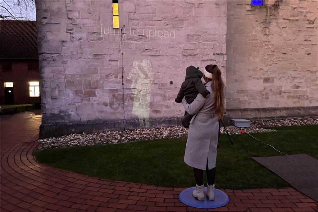 Eine Frau mit Kind auf dem Arm vor einer Kirche