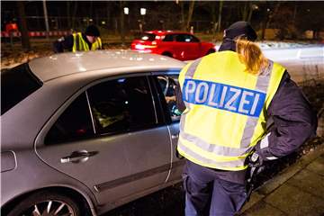 Eine Polizistin hat ein graues Auto gestoppt
