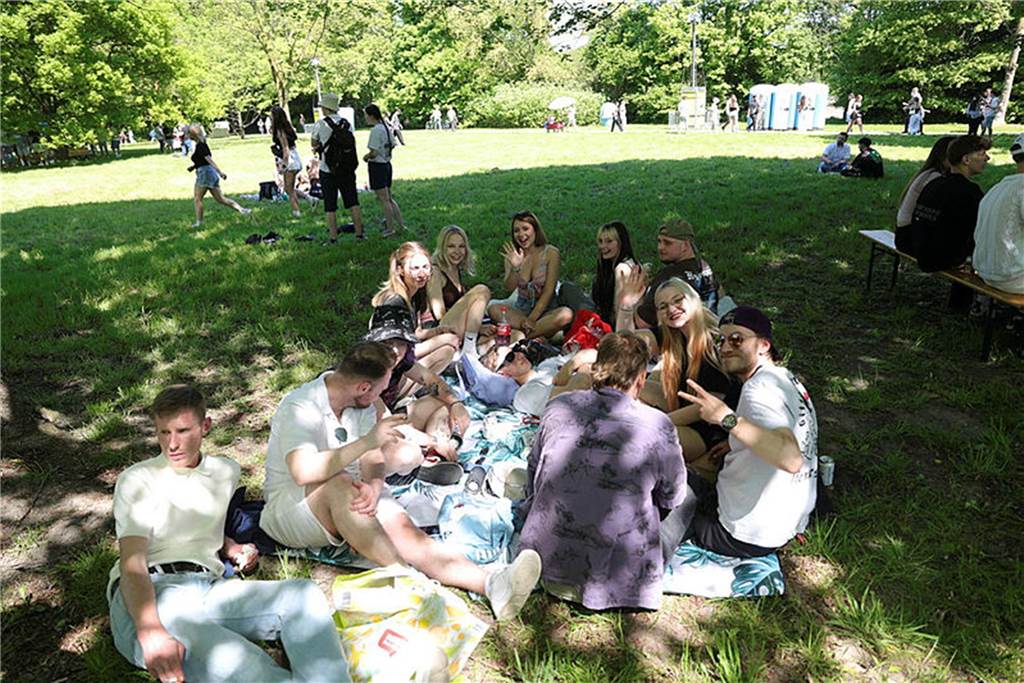 Tausende feiern den 1. Mai: Kreative Wagen, weite Anreisen und beste Laune Menschen sitzen im Schatten