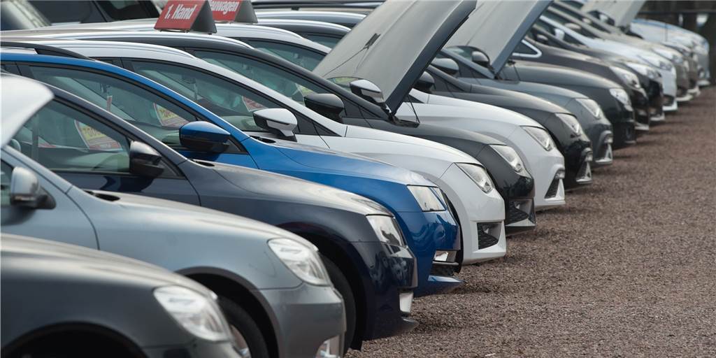Worauf Sie beim Kauf eines gebrauchten E-Autos achten sollten Auf dem Hof eines Autohändlers stehen zahlreiche gebrauchte und neue Autos