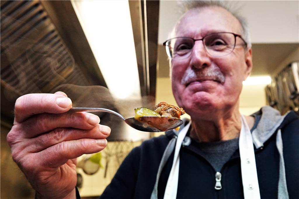 Nutrias als Braten, Gulasch oder im Salat: „Hat gar nichts mit Ratte zu tun“ Werner Steinweck, Teilnehmer des Kochkurses, hält einen Löffel mit Nutria-Curry in die Kamera und lächelt.