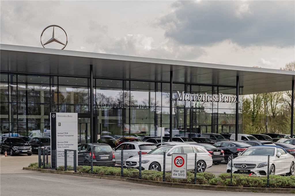 Mercedes will Niederlassungen verkaufen - Belegschaft zittert Autos vor einem Autohaus.